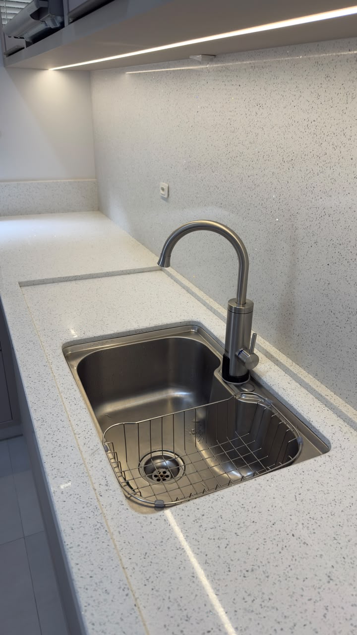 Detalhe de bancada com cuba inox embutida e frontão na mesma pedra